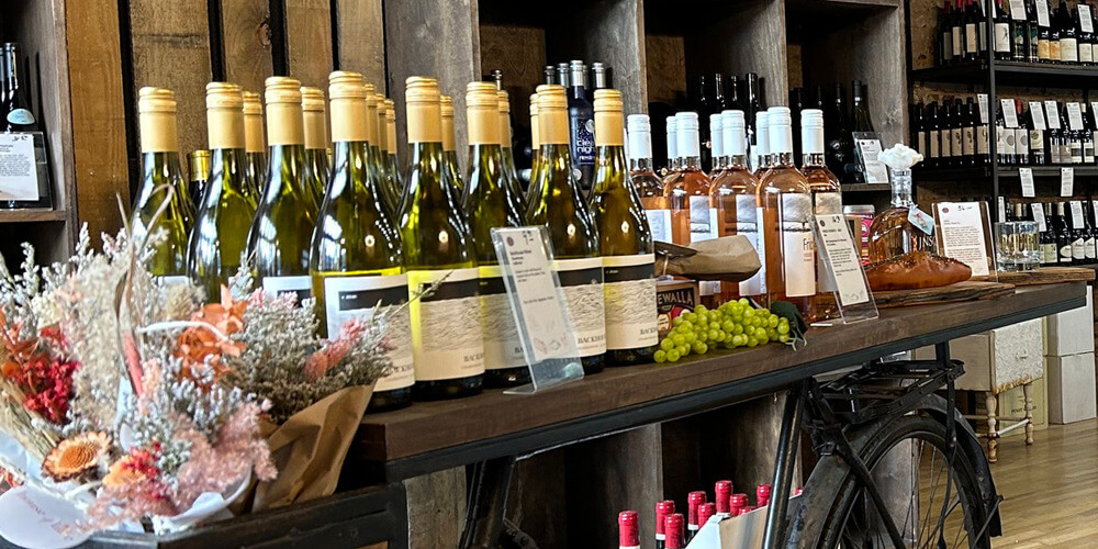 An arrangement of wines being displayed on a cart and on the shelves at Stock & Barrel